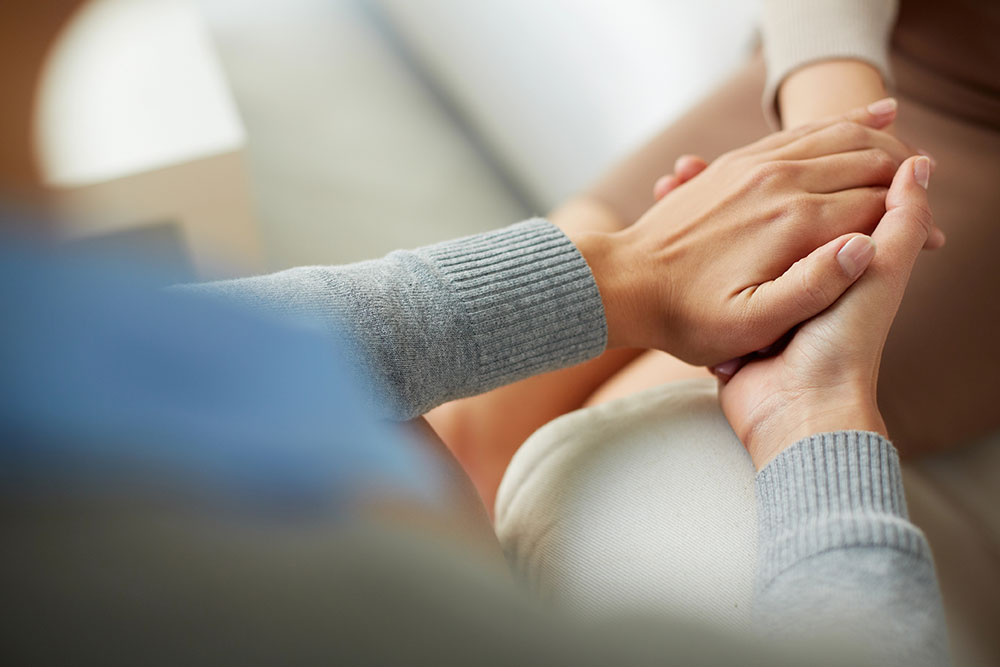 Psychiatrist hands holding palm of patient